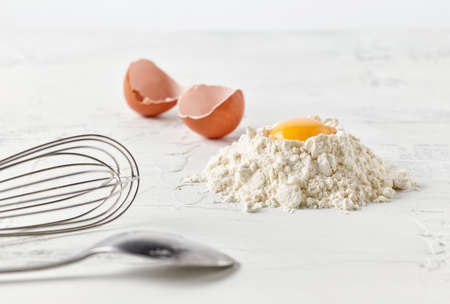 flour and egg yolk on white kitchen tableの写真素材