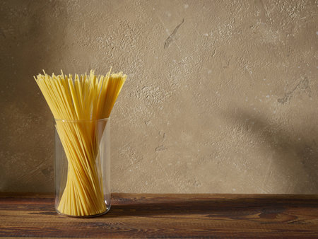 spaghetti pasta on brown kitchen wooden shelfの写真素材
