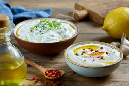 bowls of various sour cream or greek yogurt sauces on wooden kitchen table