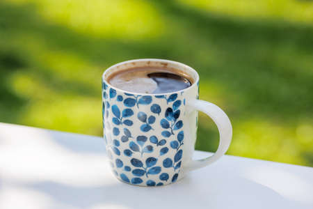 cup of coffee on white table in the garden, selective focusの写真素材