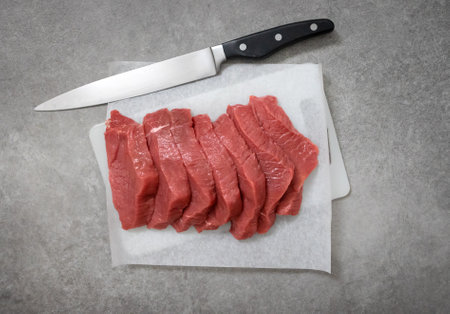 fresh raw sliced beef meat on cutting board, top viewの写真素材