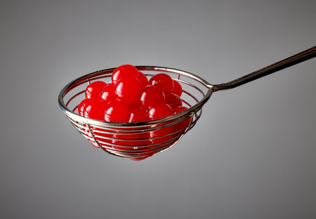 red jelly balls for making bubble tea in a strainer on grey backgroundの写真素材