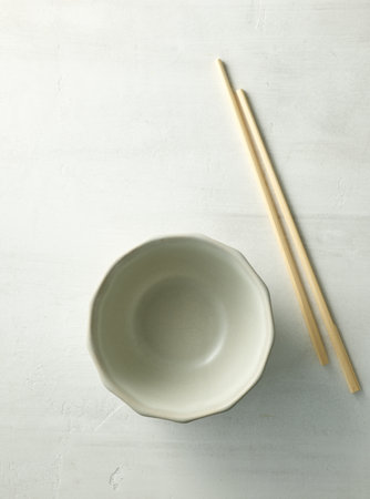 empty bowl and chopsticks on light kitchen table, top viewの写真素材