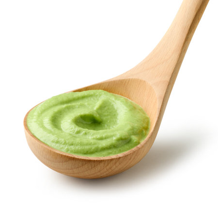 green vegetable puree in wooden ladle isolated on white backgroundの写真素材