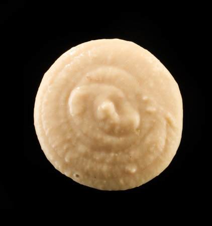 hummus macro isolated on black background, top view