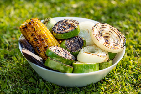 bowl of grilled vegetables on green grass background