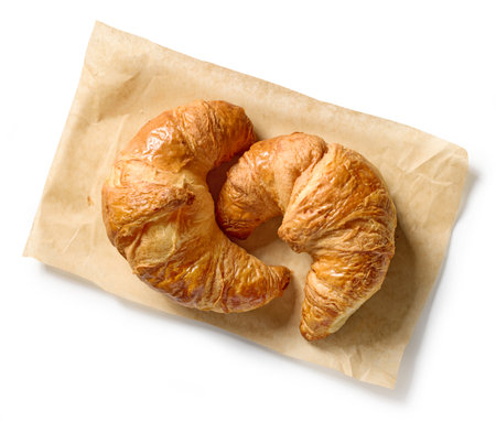 freshly baked croissants on baking paper isolated on white background, top viewの写真素材