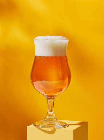 glass of beer on yellow background