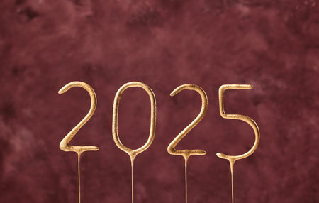 Gold sparklers numbers 2025 isolated on dark red  background