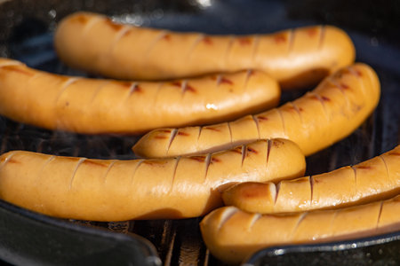 close up of grilled sausages on grill panの写真素材