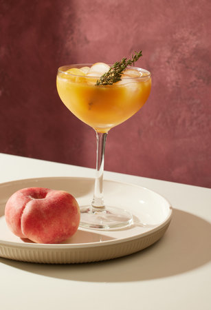 glass of iced peach juice on restaurant table on sunny dayの写真素材