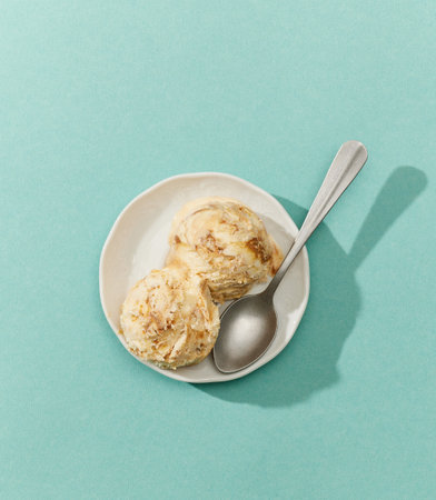 bowl of caramel ice cream isolated on blue background, top viewの写真素材