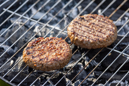 grilled burger meat patties on burning charcoal grill, selective focusの写真素材