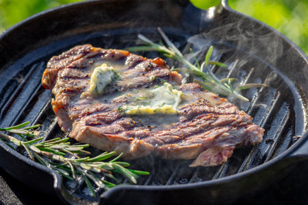 freshly grilled steak with garlic butter on grill panの写真素材