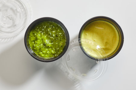 two sauces in plastic cups on white background, top viewの写真素材