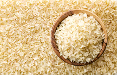 bowl of raw rice on rice background, top viewの写真素材