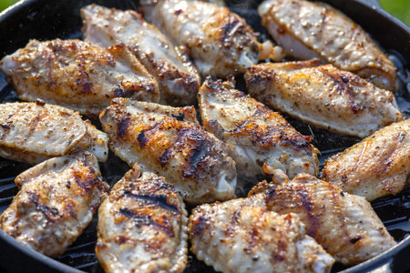 freshly grilled chicken wings on grill panの写真素材