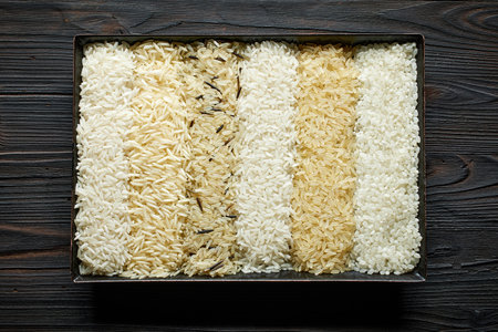 different types of rice on dark wooden table, top viewの写真素材