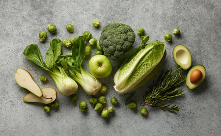 various fresh raw green vegetables on grey table, top view