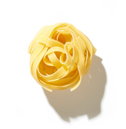 raw italian pasta tagliatelle isolated on white background, top viewの写真素材