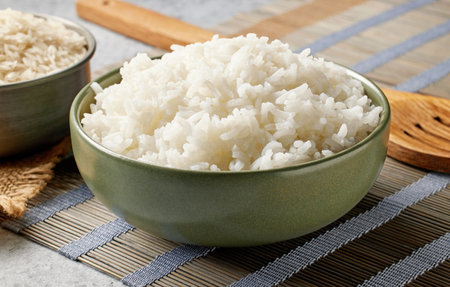 boiled rice in green bowl on kitchen tableの写真素材
