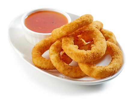 plate of fried onion rings and sauce isolated on white backgroundの写真素材