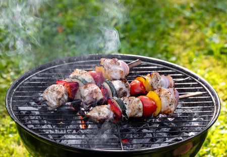 chicken meat and vegetable skewers are grilled in the gardenの写真素材