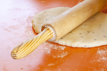 Wooden rolling pin on rolled dough with spicesの写真素材