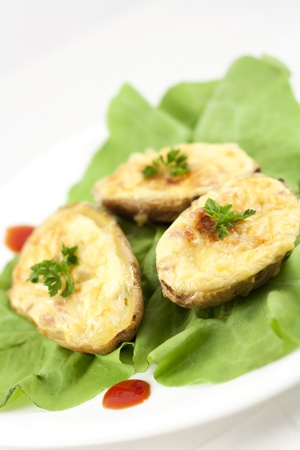 Baked potatoes filled with ham, eggs and cheese, decorated with parsley, ketchup and lettuceの写真素材
