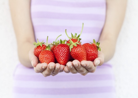 Girl hold fresh strawberries. Shallow DOF, focus on strawberries.の写真素材