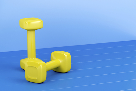 Two yellow dumbbells on shiny blue floorの写真素材