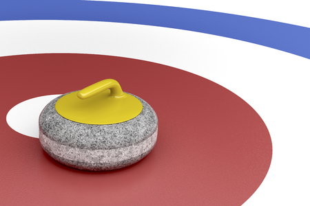 Curling stone with yellow handle in the center of target areaの写真素材