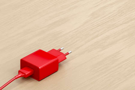 Smartphone, tablet or other electronic device charger on the wooden tableの写真素材