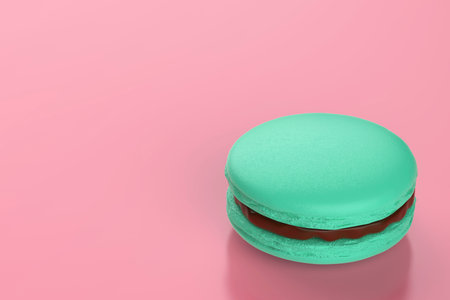 Green french macaron filled with chocolate cream on pink backgroundの写真素材