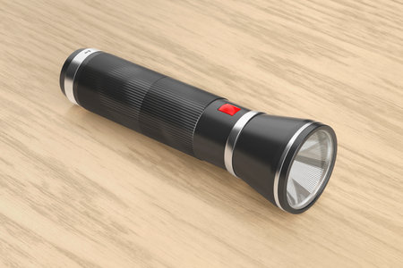 Black flashlight on a wooden desk