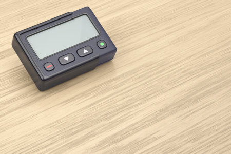 Retro pager with blank screen on wooden desk