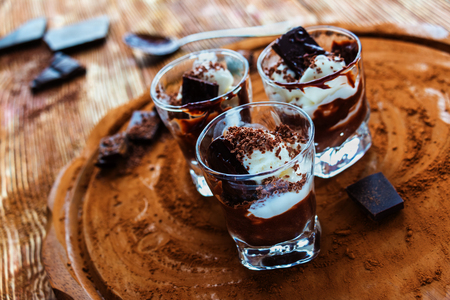 Ice cream with chocolate in small glasses on cocoa background.の写真素材