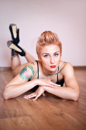 Fitness woman with a beautiful body and tattoo. Sexy glamorous blondeの写真素材
