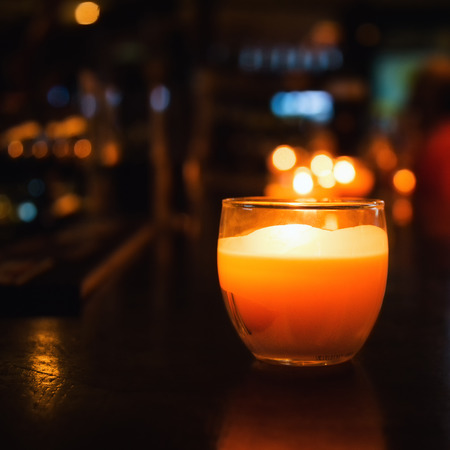 Candle in a glass. Photos of cafe or restaurant reception. Selective focus with bokeh.の写真素材