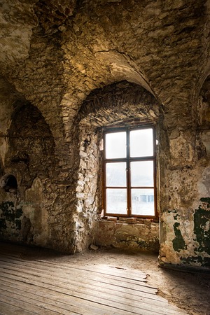 Old window of an abandoned house. Inside the old castleの写真素材