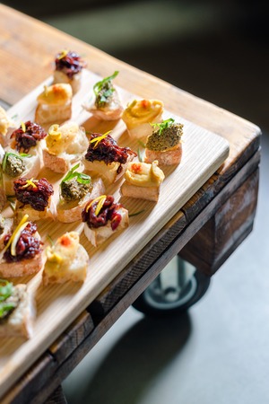 Wooden tray of appetizers on pallet coffee table at banquet