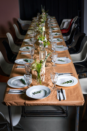 Decorated table ready for dinner. Beautifully decorated table set with flowers, candles, plates and...