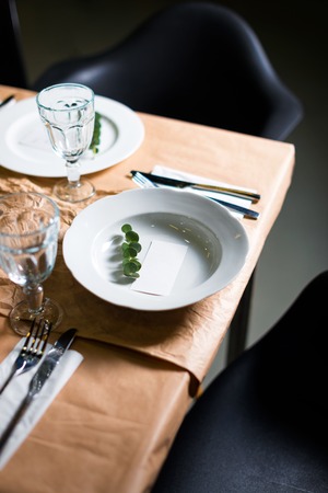 Decorated table ready for dinner. Beautifully decorated table set with flowers, candles, plates and serviettes for wedding or another event in the restaurantの写真素材