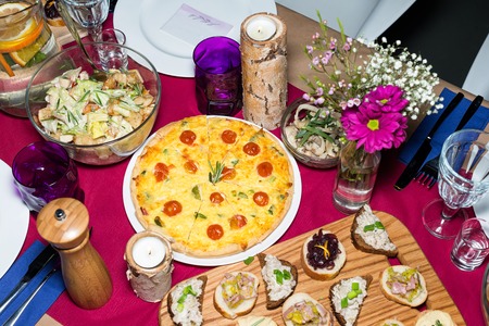 Decorated table ready for dinner. Beautifully decorated table set with flowers, candles, plates and serviettes for wedding or another event in the restaurantの写真素材