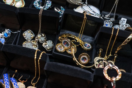 Variety of jewelry in store window. rings, necklaces, bracelets and earrings on velvet stands for saleの写真素材