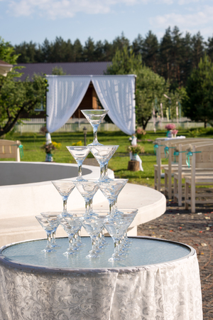 Pyramid of glasses for champagne at outdoor garden in wedding ceremonyの写真素材