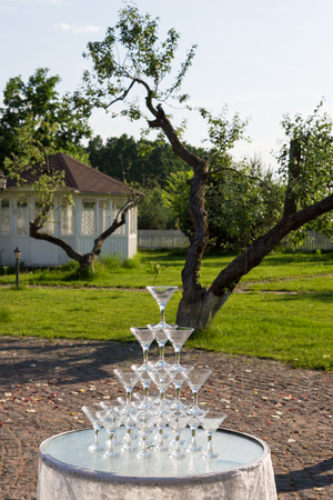 Pyramid of glasses for champagne at outdoor garden in wedding ceremonyの写真素材