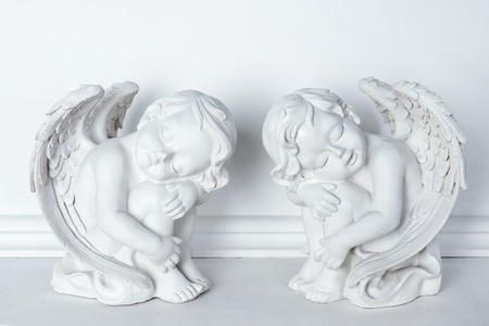 Statues of Sleeping Cupids on white backgroundの写真素材