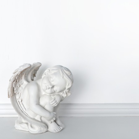 Statue of Sleeping Cupid on white background with copy space for text.の写真素材