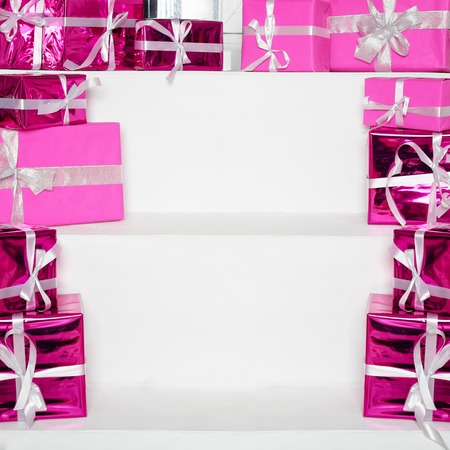 Stack of pink celebration gift boxes with ribbon bows on white table with space for text. Winter holidays conceptの写真素材